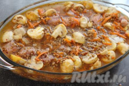 Влить 650 миллилитров воды комнатной температуры. Накрыть форму фольгой и поставить в разогретую духовку. Запекать гречку с шампиньонами и курицей примерно 1 час при температуре 200 градусов.