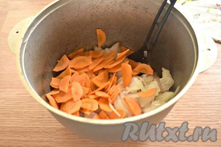 К обжаренной свинине добавляем нарезанные лук и морковь.