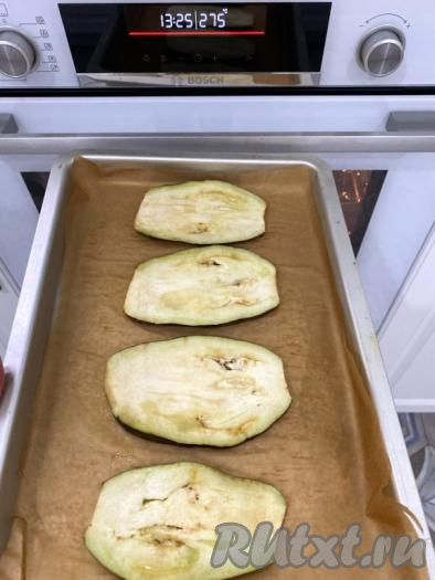 Выложить пластины баклажанов на противень, застеленный бумагой для выпечки, и поставить в разогретую до 200 градусов духовку на 15-20 минут. Баклажаны должны подрумяниться и стать мягкими, чтобы их можно было свернуть в рулетики (время запекания во многом зависит от особенностей вашей духовки). В этот раз я запекала при температуре 275 градусов на программе "Конвекция - гриль" в течение 5 минут.