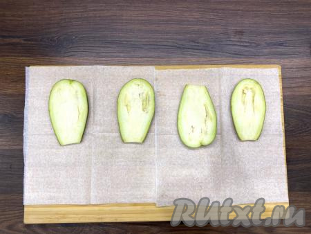 Отрезать плодоножку у баклажана. Нарезать баклажан вдоль на достаточно тонкие пластины. Посолить пластины с двух сторон и выложить на доску, застеленную бумажным полотенцем.