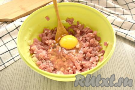 К свинине, смешанной с луком, добавляем яйцо.
