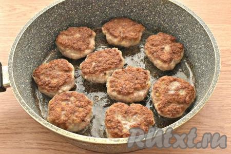 На среднем огне обжариваем котлеты с каждой стороны примерно по 5-6 минут. Затем вливаем в сковороду 100 миллилитров кипячёной воды, накрываем крышкой, даём воде закипеть и тушим котлеты на минимальном огне 5-7 минут (благодаря тушению, котлетки станут более нежными).