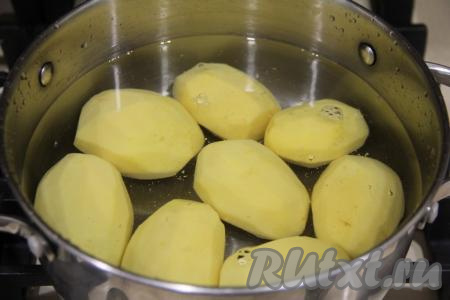 Картошку почистить, переложить в кастрюлю, полностью залить водой и отправить на огонь. Воду после закипания подсолить и варить картошины на небольшом огне в течение 7-8 минут (до полуготовности). Затем отвар слить, дать картофелинам немного остыть.