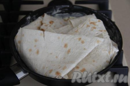 Накрыть начинку третьим листом лаваша и прижать. Завернуть все края лаваша внутрь сковороды поверх начинки.&nbsp;