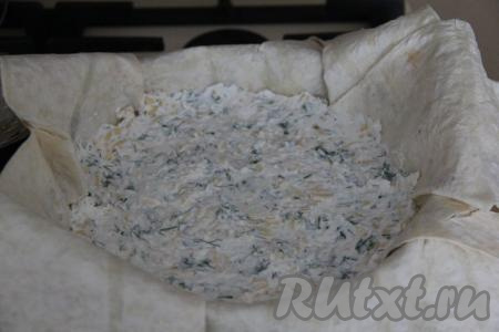 В сковороду, застеленную лавашом, выложить сырную начинку, разровнять и слегка утрамбовать.