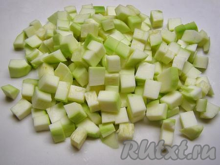 Кабачки хорошо моем, удаляем плодоножку и счищаем с них кожуру. Молодой кабачок с мелкими семечками можно готовить, не очищая от семян. Если у кабачка крупные семечки, их нужно удалить. Нарезаем 1 килограмм очищенных кабачков на кубики размером примерно 1 на 1 сантиметр.