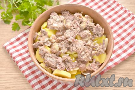 Тушёнку разминаем вилкой, а затем равномерно раскладываем поверх картошки.