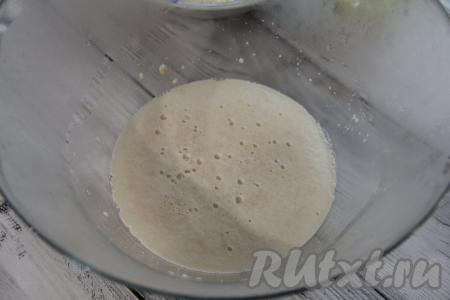 Воду подогреть примерно до 40 градусов (если вода будет более горячей или холодной, дрожжи не "заработают"), влить в объёмную миску, всыпать дрожжи и сахар, перемешать и оставить получившуюся опару в тёплом месте до появления на поверхности пышной пенной шапки (примерно на 10-15 минут).