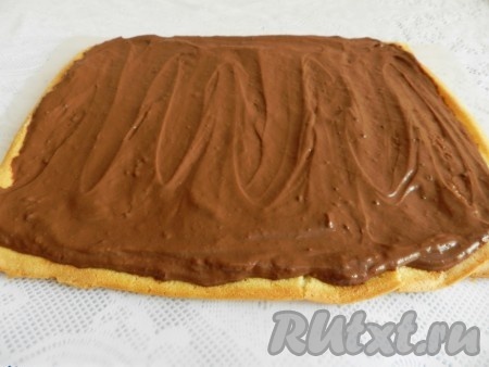 Бисквитный корж развернуть, смазать кремом.
