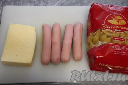 Подготовить продукты для приготовления макарон с сосисками и сыром на сковороде. Сосиски очистить от плёнки.