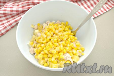 В получившийся салат с курицей и ананасами выкладываем консервированную кукурузу из банки без жидкости, перчим.