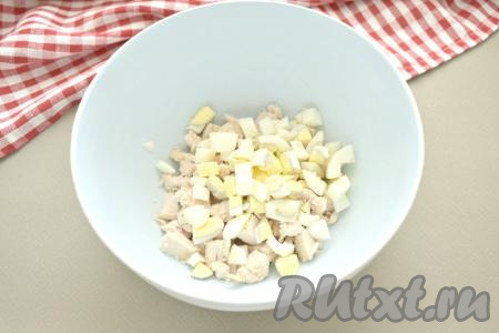 Яйца тоже нарезаем на средние кубики и добавляем в миску с курицей.