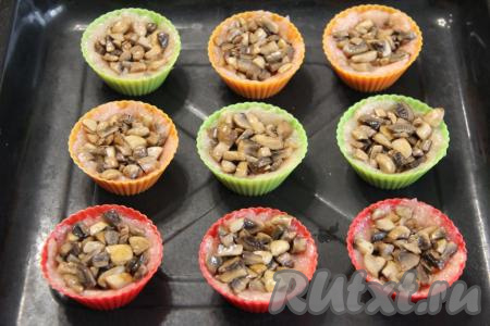 Поставить формы с фаршем на противень. Разложить грибную начинку по корзинкам поверх фарша.