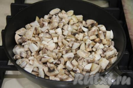 В сковороду влить масло, разогреть. Шампиньоны (или отваренные лесные грибы) мелко нарезать. Добавить грибы в сковороду с маслом.&nbsp;