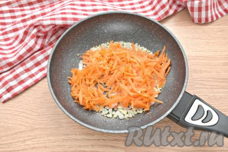 Очищенную морковку, натёртую на крупной тёрке, выкладываем к обжаренному луку. Обжариваем овощи минут 5, не забывая перемешивать.