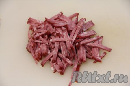 Копчёную колбаску нарезать на длинные брусочки.