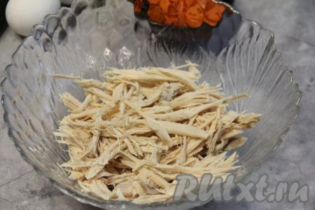 Порвать остывшее куриное мясо на волокна и выложить в салатник.