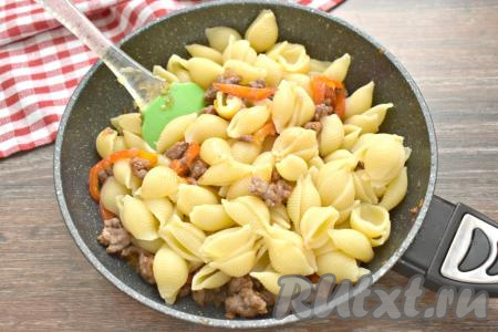 Откидываем отваренные макароны на дуршлаг, давая полностью стечь воде. Макароны перекладываем на сковороду к мясному фаршу, обжаренному с болгарским перцем, перемешиваем, томим под крышкой минуты 3, за это время блюдо можно пару раз перемешать.