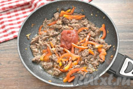 После этого в сковороду добавляем томатную пасту, вливаем 2-3 столовых ложки воды из кастрюли, в которой варятся макароны. Тушим под крышкой фарш с перцем 7-8 минут на малом огне (до готовности фарша), иногда перемешивая.