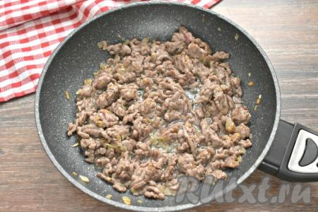 Фарш с луком солим, перчим и обжариваем около 7 минут, разбивая кусочки мяса лопаточкой.