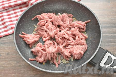 К обжаренному луку добавляем мясной фарш, сразу перемешиваем.