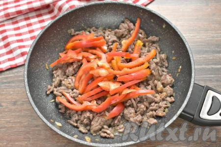Очищаем болгарский перец от семян, ополаскиваем его водой, нарезаем соломкой и добавляем к фаршу, обжаренному с луком. Перемешиваем, обжариваем фарш с перцем минуты 3, периодически помешивая.