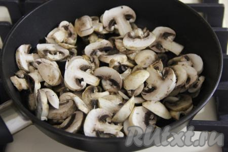 Шампиньоны промыть, нарезать на пластинки и обжарить на растительном масле на среднем огне в течение 15 минут, время от времени помешивая, затем убрать с огня и оставить остывать.