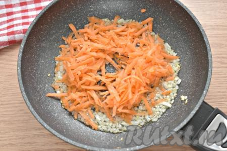 Натираем морковку на крупной тёрке и перекладываем её к мягкому луку, обжариваем овощи вместе 4-5 минут (до мягкости морковки).