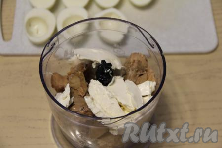 С печени трески слить лишний жир (жир нам не понадобится). Переложить печень в измельчитель, добавить творожный сыр. Очищенные яйца разрезать в длину на две равные половинки. Вынуть желтки и добавить их к сыру и печени. Я фаршировала муссом яйца, поэтому получившиеся лодочки из белка пока отложила в сторону. 