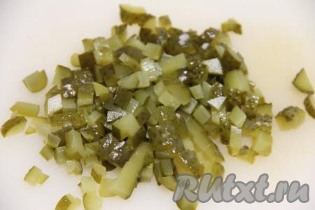 Нарезать на небольшие кубики маринованные огурцы.