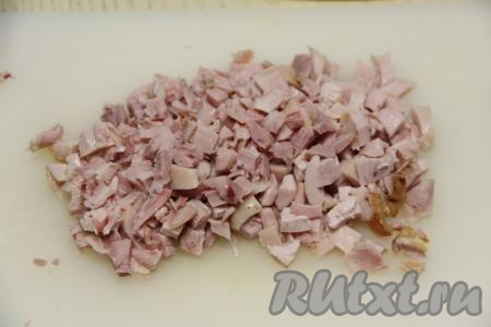 Все ингредиенты для "Оливье" нужно стараться нарезать на кубики одинакового размера. Размер нарезанных ингредиентов должен быть не больше размера консервированного горошка. Нарезать копчёную курицу на небольшие кубики.