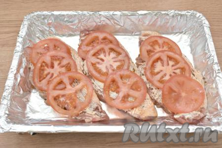 Помидор моем, нарезаем на тонкие кружочки. Выкладываем нарезанные помидоры поверх свинины.