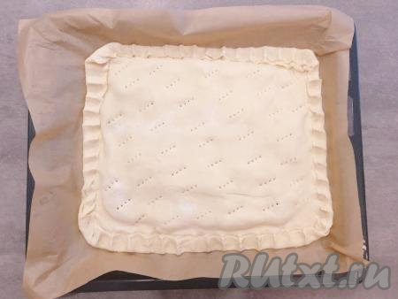 Сверху накрываем второй половиной теста, защипываем края и делаем вилкой дырочки для выхода пара.