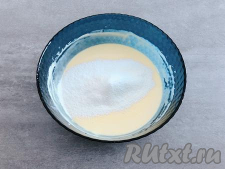 Желтки по одному вводим в сырную смесь, вмешивая каждый желток с помощью венчика. В сырно-желтковую массу добавляем лимонный сок и ванильный сахар, размешиваем венчиком до однородности. Затем сюда же просеиваем муку и крахмал, снова перемешиваем.