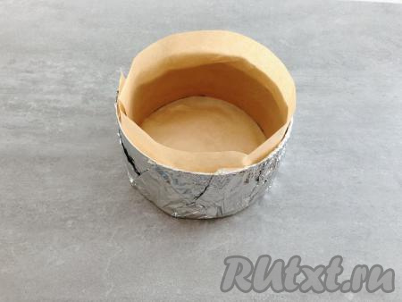 Теперь подготовим форму для выпечки. Я использую раздвижное кондитерское кольцо диаметром 18 сантиметров, высота 8,5 сантиметров. Снаружи его необходимо плотно обернуть фольгой в несколько слоёв, а стенки и дно изнутри выстелить пергаментом для выпечки. Смазывать маслом не потребуется.