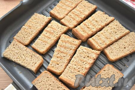 Ломтики хлеба разрезаем пополам. Подсушиваем хлеб на горячей сухой сковороде с двух сторон (примерно по одной минуте с каждой стороны). Я использовала сковороду-гриль, подойдёт и обычная сковорода, также можно подсушить хлеб в тостере.