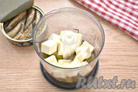 Плавленный сыр нарезаем на небольшие кубики и перекладываем к огурцам в чашу измельчителя.