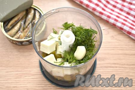 Ополаскиваем водой веточки укропа, обсушиваем, нарезаем крупно и вместе с очищенным зубчиком чеснока добавляем в чашу измельчителя. 