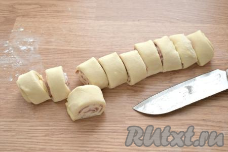 Получившийся рулет нарезаем острым ножом на одинаковые кусочки шириной примерно 2-3 сантиметра. У меня получилось 10 заготовок слоек с беконом.