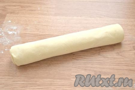 Сворачиваем тесто с беконом в рулет, начиная с широкой стороны.