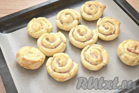 Отправляем противень с заготовками слоек с беконом в предварительно разогретую до 180 градусов духовку на 25-30 минут (ориентируйтесь на свойства своей духовки). Слойки должны увеличиться в размере и подрумяниться.