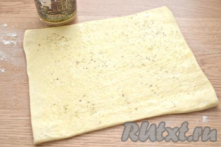 Яйцо взбиваем вилкой (или венчиком), а затем смазываем им всю поверхность раскатанного пласта теста (часть взбитого яйца оставляем для смазывания слоек перед выпечкой). Немного солим смазанное тесто и перчим.