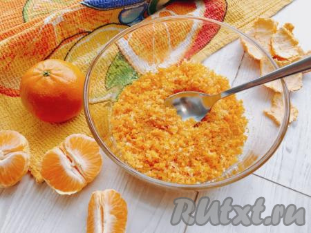 Мандарины моем в горячей воде, обсушиваем полотенцем и при помощи мелкой тёрки снимаем с них цедру (снимая оранжевую цедру с мандаринов, стараемся не затрагивать, находящийся под ней белый слой). У меня получилось 2 столовых ложки с горкой мандариновой цедры. Цедру перекладываем в миску. Всыпаем к цедре сахар, тщательно растираем ложкой и отставляем в сторону настояться в течение 15-20 минут.