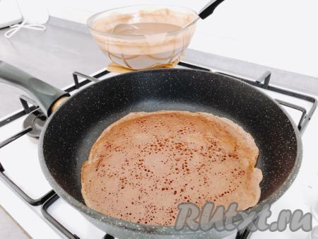 Перед выпеканием блинов готовому заварному тесту нужно дать постоять 30 минут. После этого можно начинать жарить блинчики. Хорошенько разогреваем сковороду, при помощи силиконовой кисточки слегка смазываем её растительным маслом (можно просто налить немного масла на сковороду и распределить). Затем один половник теста выливаем в сковороду и равномерно распределяем его по всей поверхности. Выпекаем блинчик по 1-2 минуте с каждой стороны, затем перекладываем на тарелку.