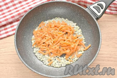 Когда лук станет прозрачным, добавляем к нему очищенную и натёртую на крупной тёрке морковку, обжариваем овощи, иногда помешивая, на среднем огне 3-4 минуты.