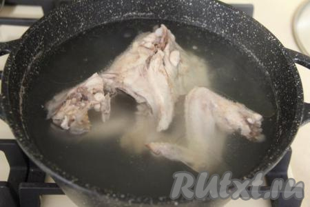 Кусочки курицы на кости (например, можно взять окорочок или пару ножек, крылышек) вымыть, переложить в кастрюлю, залить 2,5 литрами воды. Поставить кастрюлю на огонь, после закипания, сняв с бульона пенку, варить на небольшом огне минут 35-40.