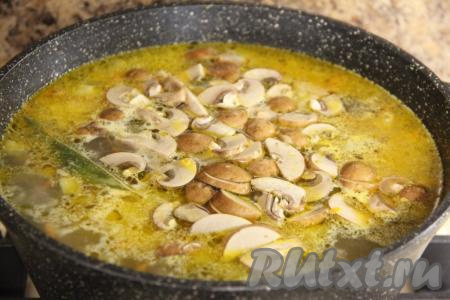 Добавить грибы и огурцы в кастрюлю, дать закипеть и варить рассольник 10 минут на небольшом огне.