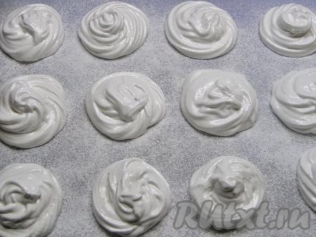 Застилаем доску пергаментной бумагой и присыпаем её сахарной пудрой. Отсаживаем зефир на бумагу в виде кружочков диаметром 5 сантиметров.