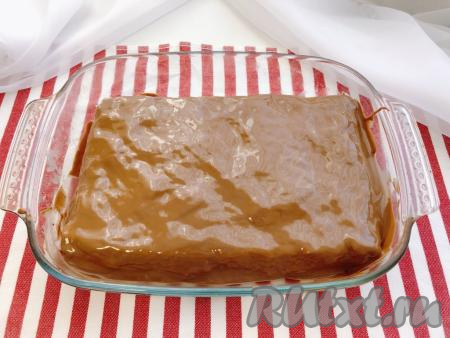 Достаём десерт из холодильника, снимаем с него пищевую плёнку, выливаем тёплую глазурь и распределяем её по всей поверхности, наклоняя форму в разные стороны. В результате у нас получится идеально гладкая поверхность.&nbsp;На этом этапе снова ставим десерт в холодильник, на этот раз на 20-30 минут. Этого времени будет вполне достаточно для того, чтобы глазурь полностью застыла.