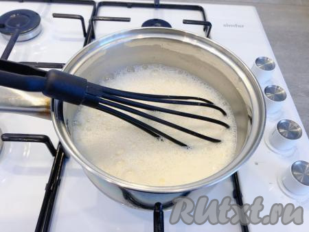 Тщательно перемешиваем молочно-яичную смесь венчиком до тех пор, пока не растворятся все комочки. Добавляем оставшееся молоко, снова перемешиваем. Ставим на огонь чуть выше среднего и нагреваем, периодически помешивая.